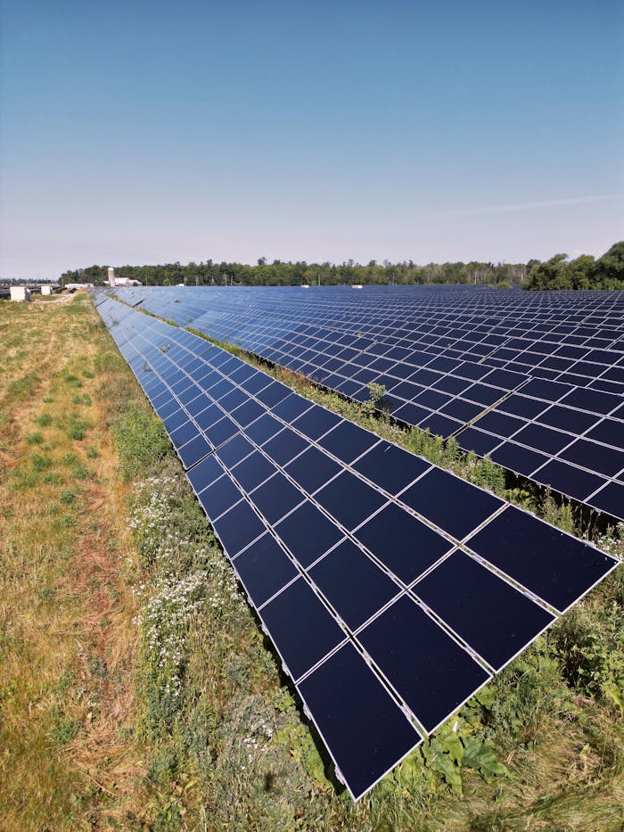 hero-services Wide view of a solar panel farm under a clear blue sky in Mississippi Mills, ON, promoting renewable energy.